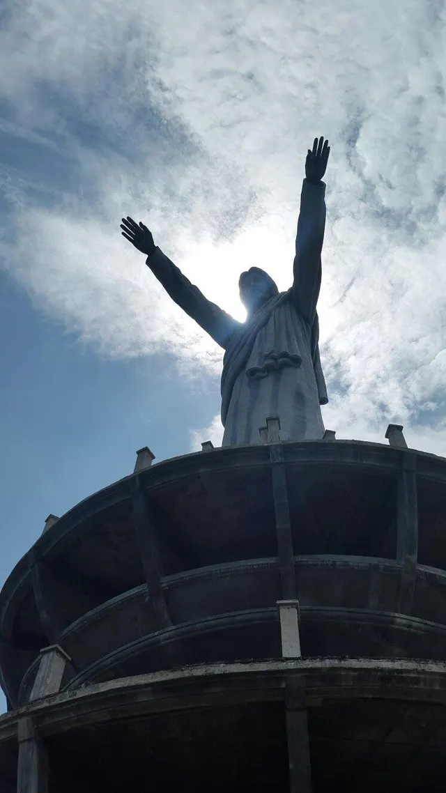 The Buntu Burake statue seen from below, arms outstretched