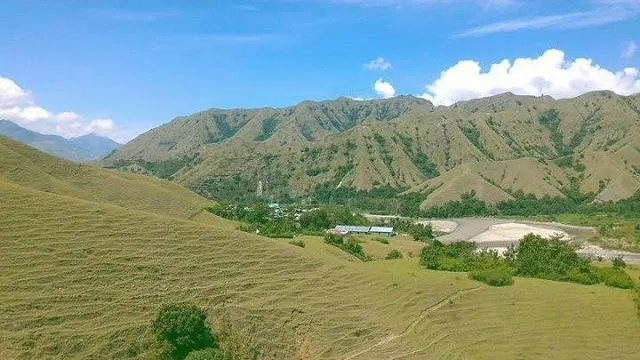 Rolling grass hills above the valley floor at Ollon